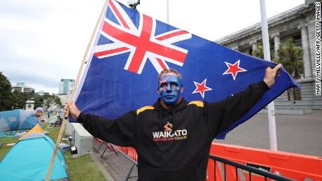 Un manifestante sostiene una bandera de Nueva Zelanda frente a los edificios del Parlamento en el cuarto día de manifestaciones contra las restricciones de Covid-19 en Wellington el 11 de febrero.