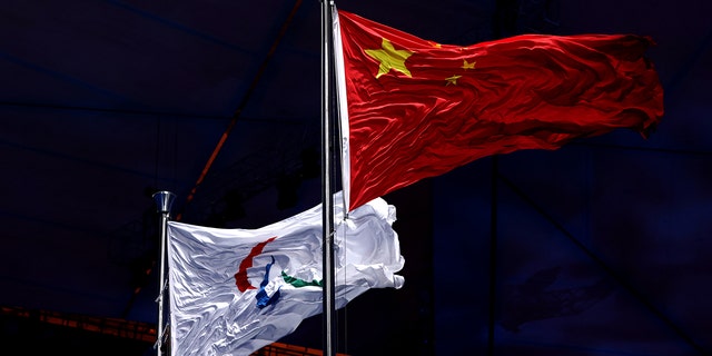 La bandera Paralímpica se iza junto con la bandera china durante la ceremonia de apertura de los Juegos Paralímpicos de Invierno de Beijing 2022 en el Estadio Nacional de Beijing el 4 de marzo de 2022 en Beijing, China. 