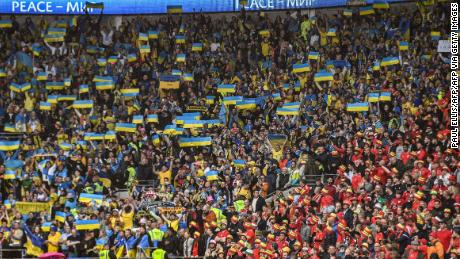 Aficionados de Ucrania izan la bandera de su país en el Cardiff City Stadium. 
