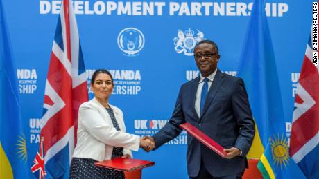 La ministra del Interior británica, Priti Patel, le da la mano al ministro de Relaciones Exteriores de Ruanda, Vincent Beirutari, después de firmar el acuerdo de asociación en una conferencia de prensa conjunta en Kigali, Ruanda, el 14 de abril.