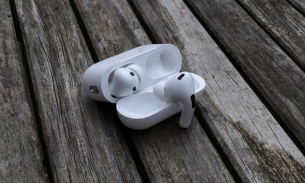 Estuche AirPods Pro 2 abierto sobre una mesa con un auricular colgando de la tapa.