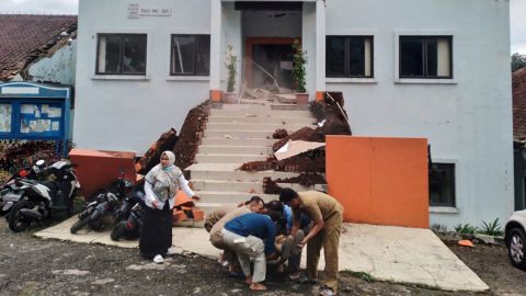 Funcionarios municipales de Cianjur evacuan a un colega herido tras el terremoto.